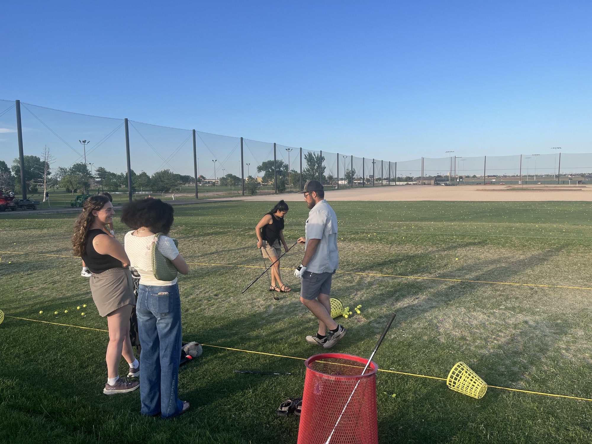 Khale Lucero showing Gaire Lab members how to play golf